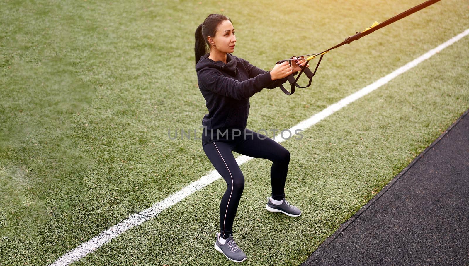 Girl athlete training sportground Mixed race young adult woman workout suspension system Healthy lifestyle Stretching outdoors playground. Make your body machine