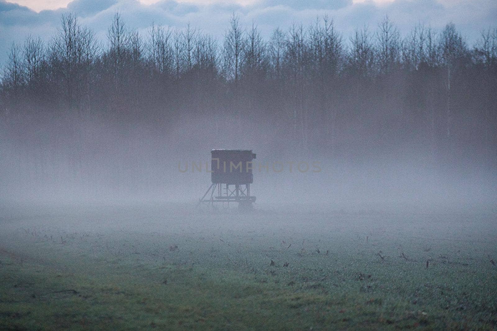 A landscape in the evening with fog and sunset
