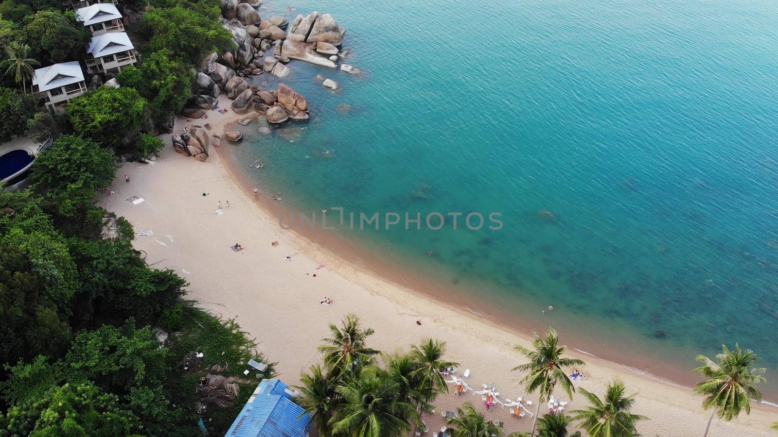 Villas on green mountain ridge. Majestic drone view of luxury villas located on green mountain range on tropical paradise island near the tiny beach. Stony shore and green jungle of volcanic Koh Samui by DogoraSun