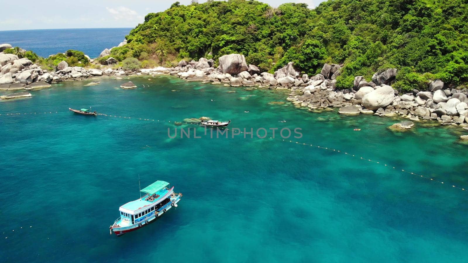 Tourist boats in tropical bay. Drone view of tourist boats with divers and snorkelers floating on calm sea water in Hin Wong Bay of tropical volcanic Koh Tao Island in Thailand. by DogoraSun