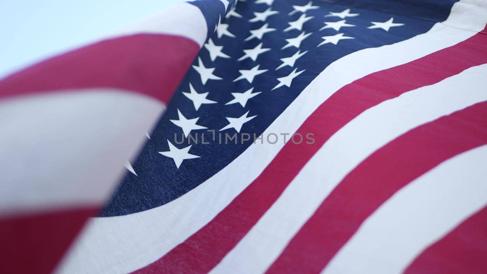 Soft focus close up of American Old Glory flag waving on wind. Stars and Stripes democracy, patriotism, freedom and Independence Day symbol. Star-spangled Banner, national pride and icon of liberty.