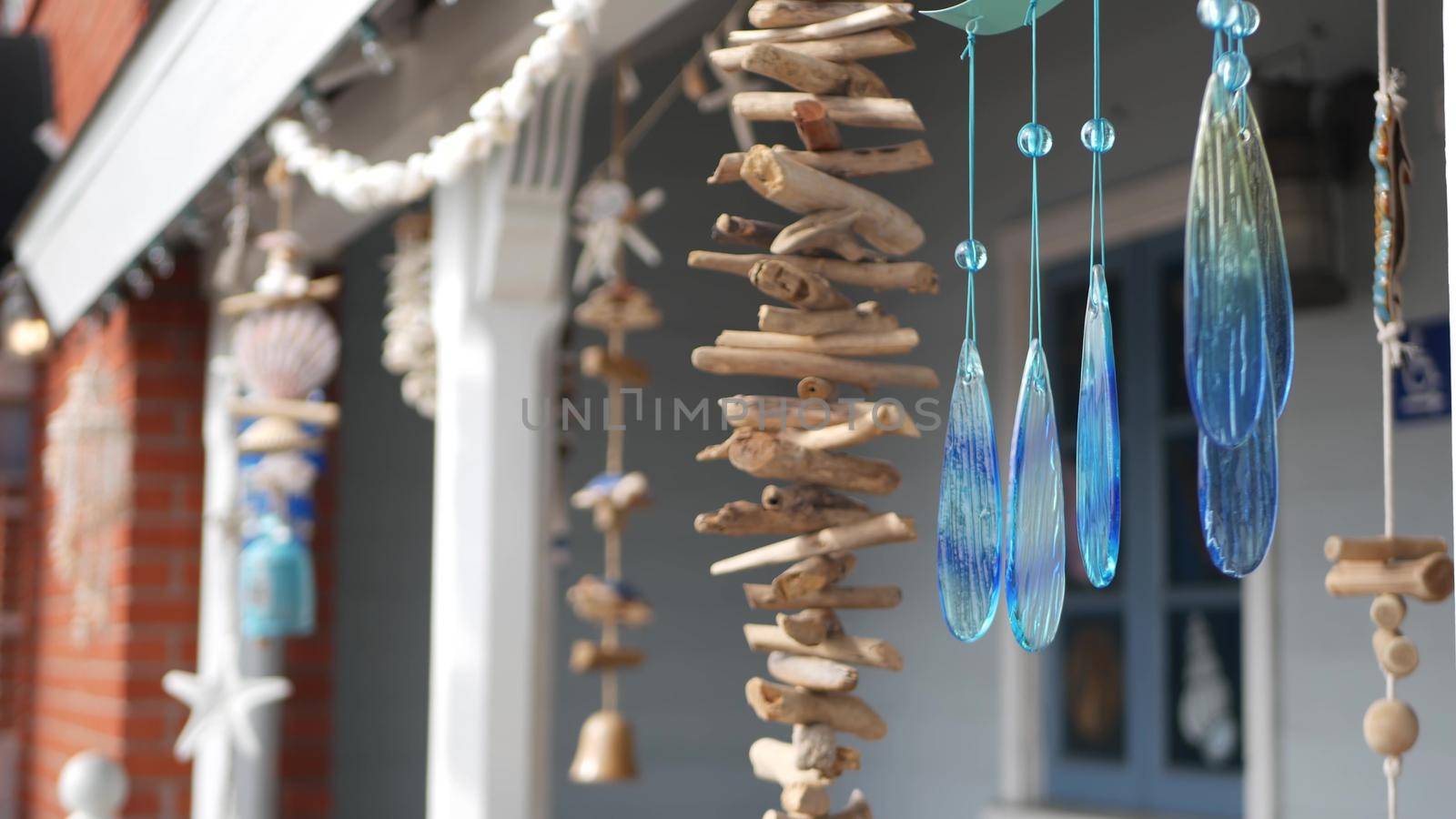 Nautical style hanging seashells decoration, beachfront blue wooden holiday home, pacific coast, California USA. Marine pastel interior decor of beach house in breeze. Summertime sea wind aesthetic by DogoraSun