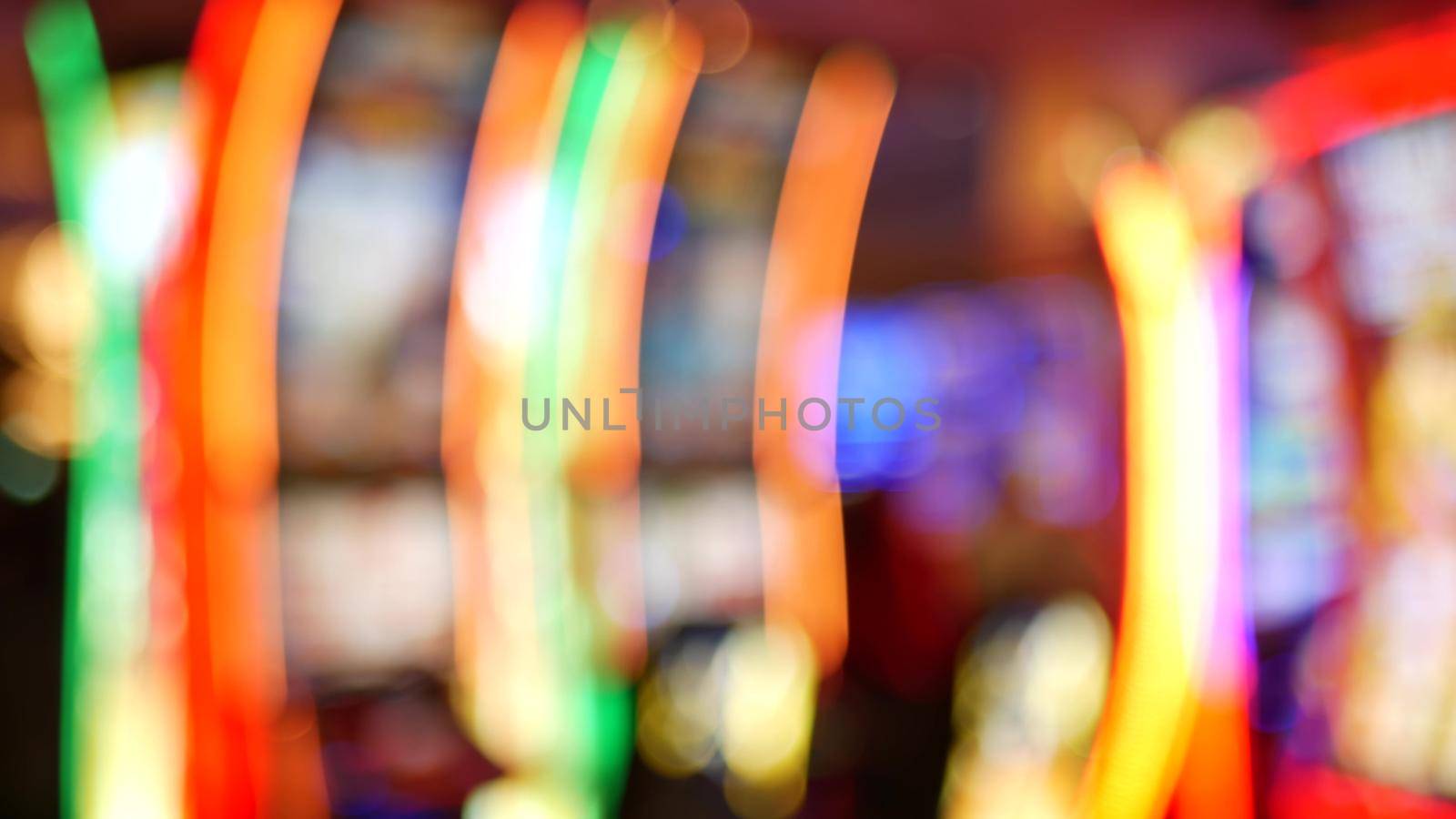 Defocused slot machines glow in casino on fabulous Las Vegas Strip, USA. Blurred gambling jackpot slots in hotel near Fremont street. Illuminated neon fruit machine for risk money playing and betting.