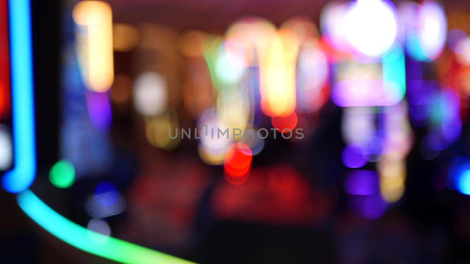 Defocused slot machines glow in casino on fabulous Las Vegas Strip, USA. Blurred gambling jackpot slots in hotel near Fremont street. Illuminated neon fruit machine for risk money playing and betting.