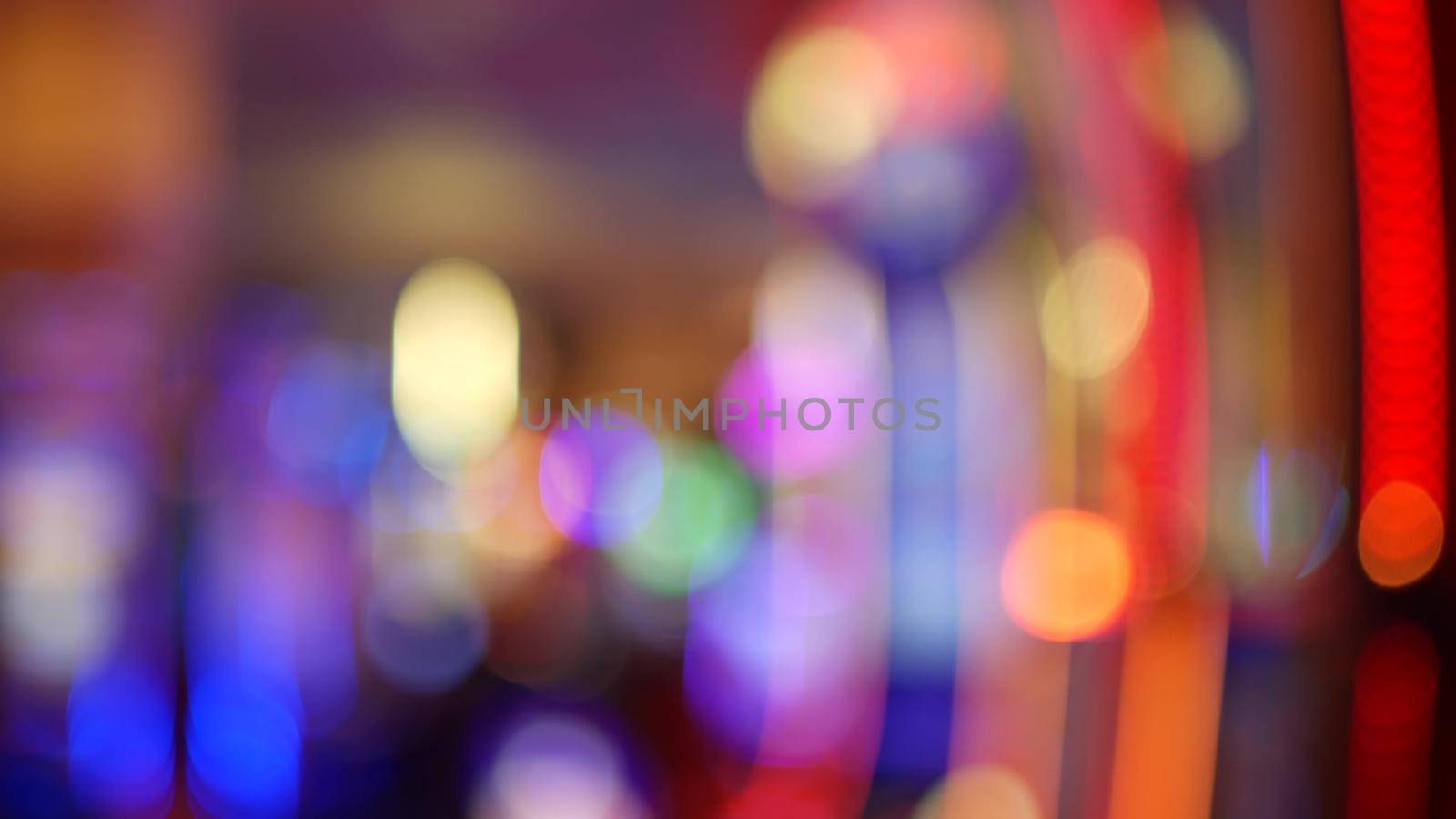 Defocused slot machines glow in casino on fabulous Las Vegas Strip, USA. Blurred gambling jackpot slots in hotel near Fremont street. Illuminated neon fruit machine for risk money playing and betting.