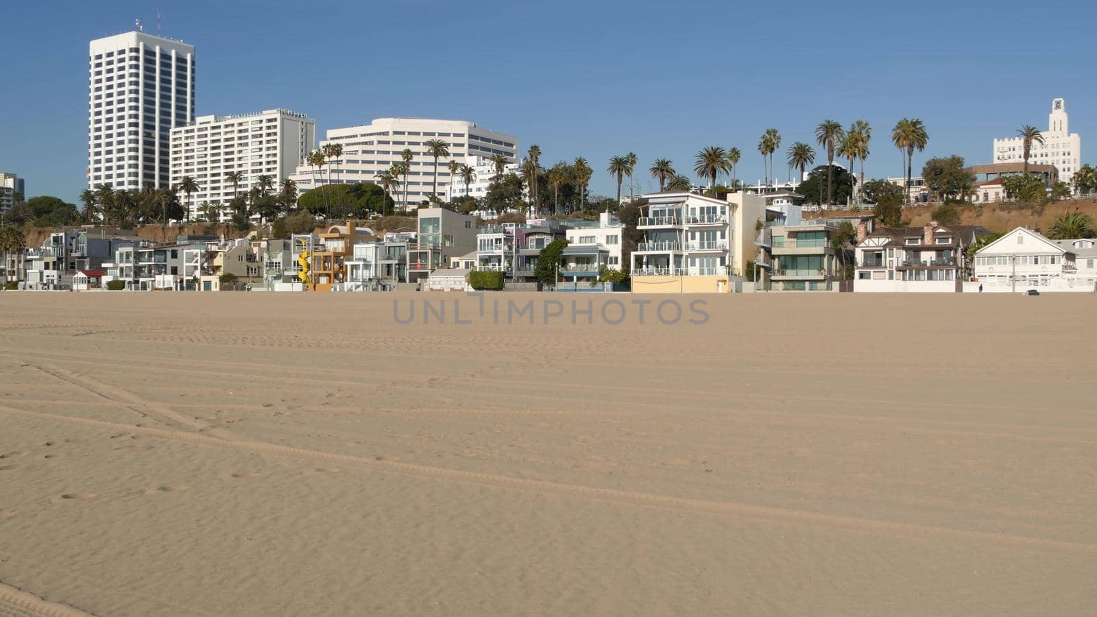 California summertime beach aesthetic, sunny blue sky, sand and many different beachfront weekend houses. Seafront buildings, real estate in Santa Monica pacific ocean resort near Los Angeles CA USA by DogoraSun