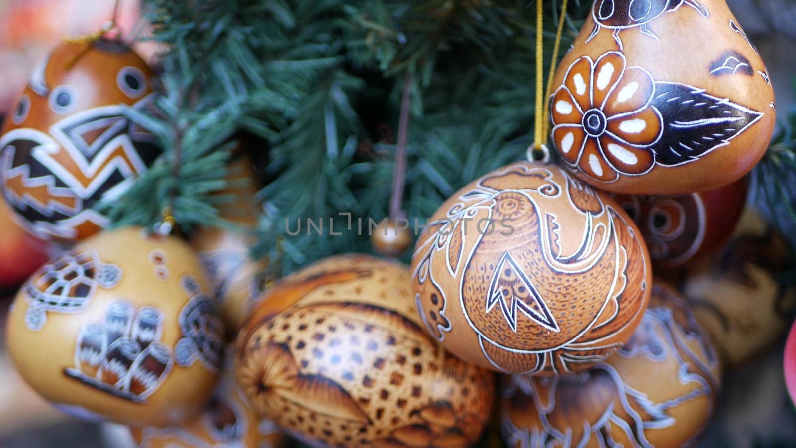 Wooden ornamental handmade mexican decor. Indigenous souvenirs hanging on new year tree, handicraft market, California USA. Hispanic authentic pattern, folk traditional handiwork from Latin America.