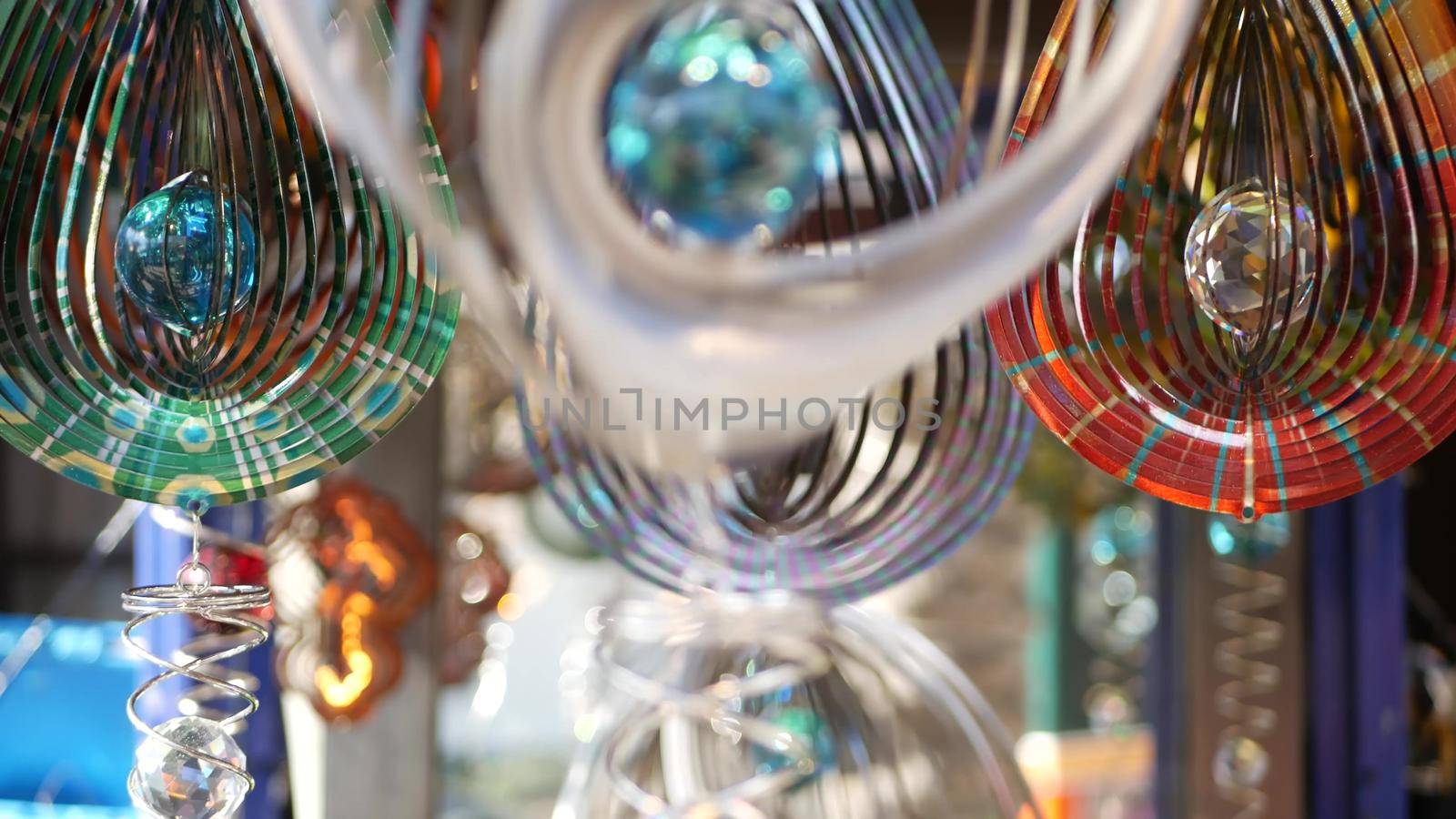 Colorful geometric metallic wind spinner, garden hypnotic surreal decoration, California USA. 3D kinetic rotating iridescent magnetic multi colored air spiral. Shimmering mesmerising optical illusion.