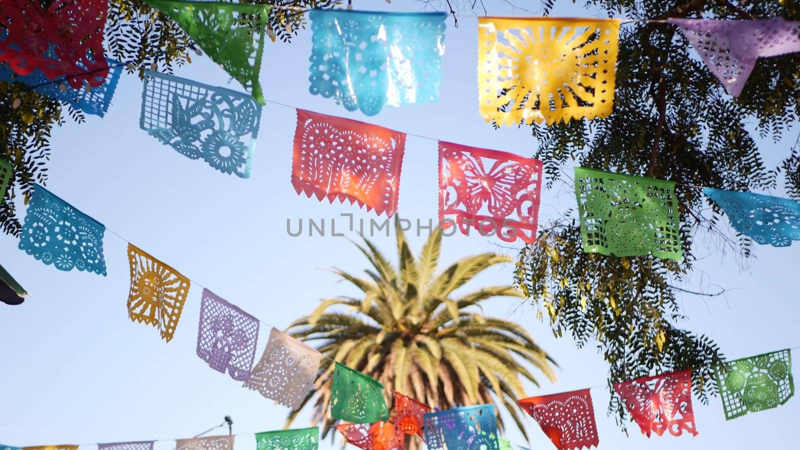 Colorful mexican perforated papel picado banner, festival colourful paper garland. Multi colored hispanic folk carved tissue flags, holiday or carnival. Authentic fiesta decoration in Latin America.