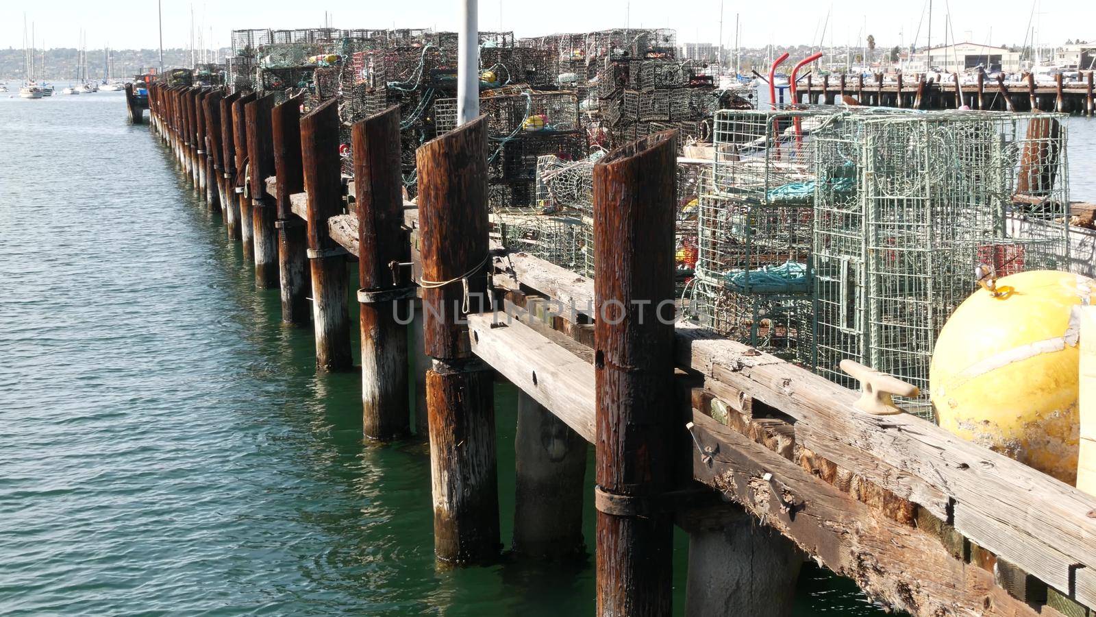 Traps, ropes and cages on pier, commercial dock, fishing industry in San Diego harbor, California USA. Empty pots and creels for seafood catching in port. Many fishermen's nets and baskets in seaport.