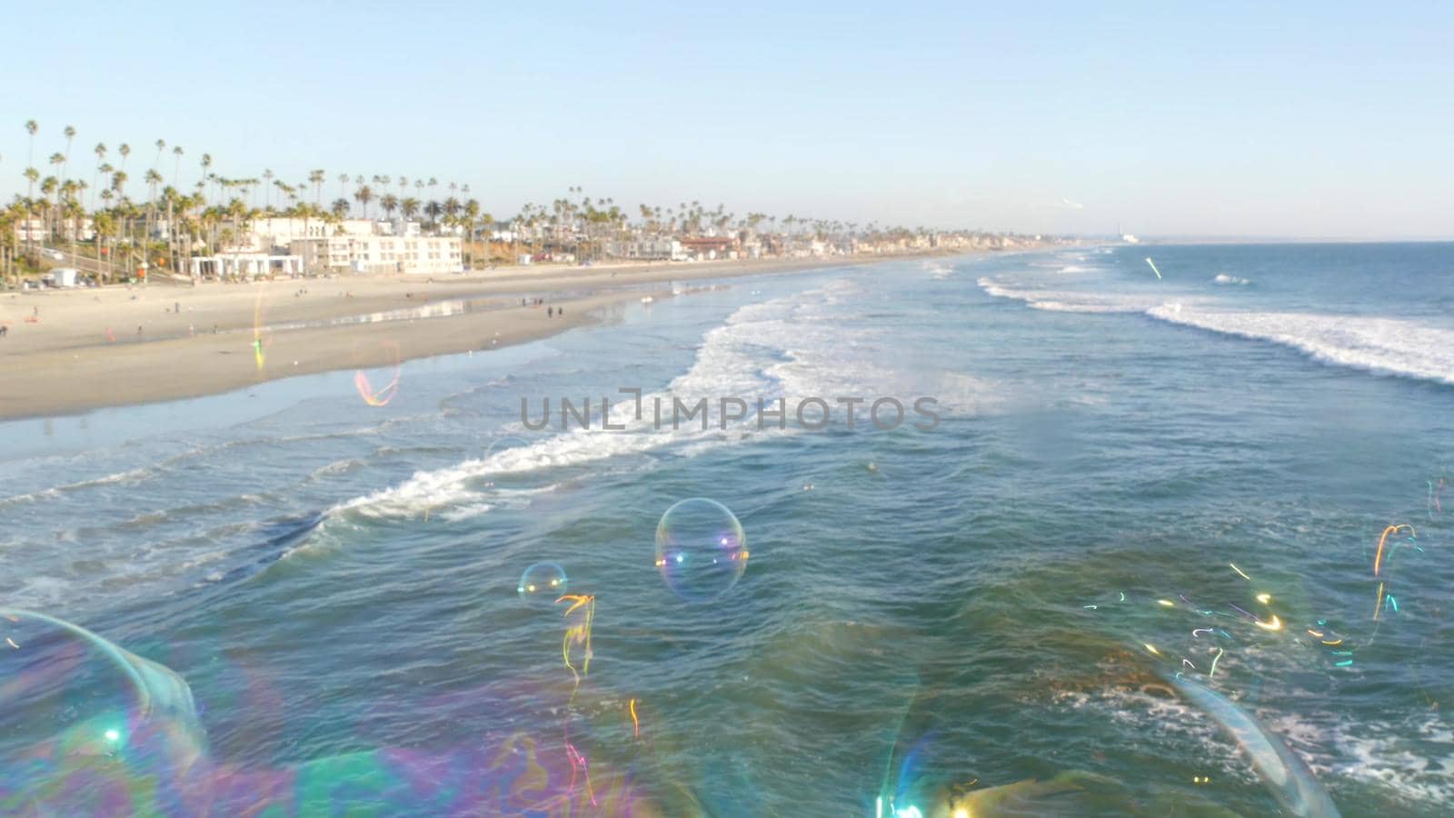Soap bubbles on pier in California, blurred summertime seamless looped background. Creative romantic metaphor, concept of dreaming, happiness and magic. Abstract symbol of childhood, fantasy, freedom by DogoraSun