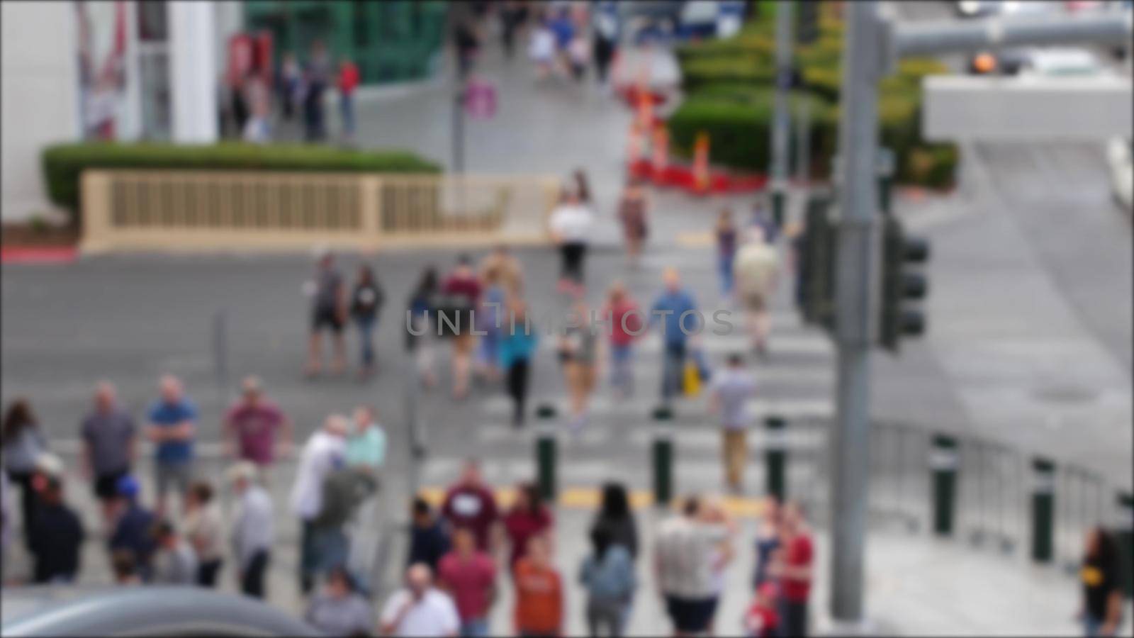 Defocused crowd of people, road intersection crosswalk on The Strip of Las Vegas, USA. Anonymous blurred pedestrians on walkway in crowded urban downtown. Unrecognizable american citizens in sin city by DogoraSun