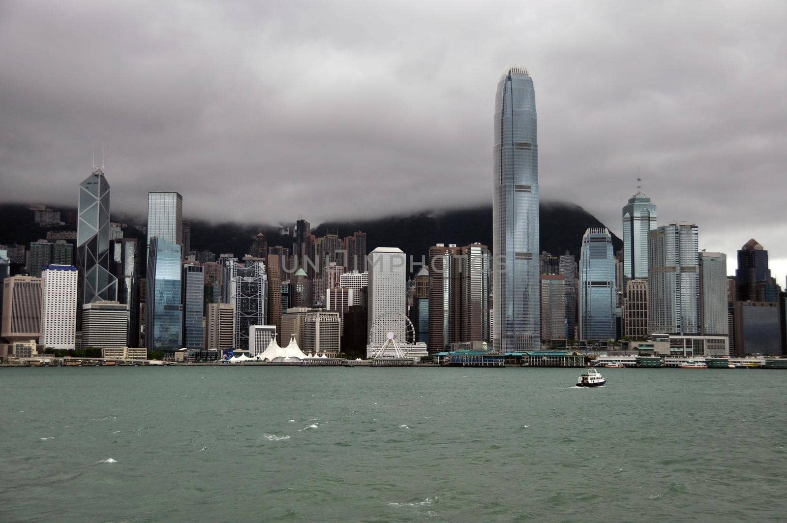 Hong Kong panorama in stormy day. Skyline of Hong Kong with rough waves of sea in stormy cloudy day. by DogoraSun