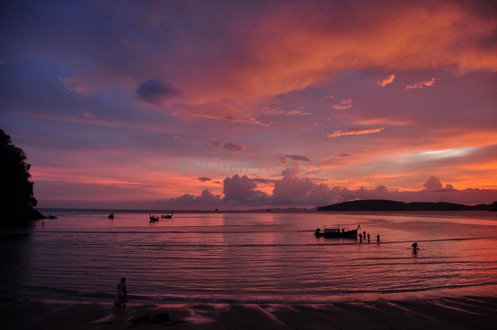 Beautiful sunset on shoreline, Picturesque view of Ao Nang beach with calm waves running on coast against multicolored sunset sky, Thailand