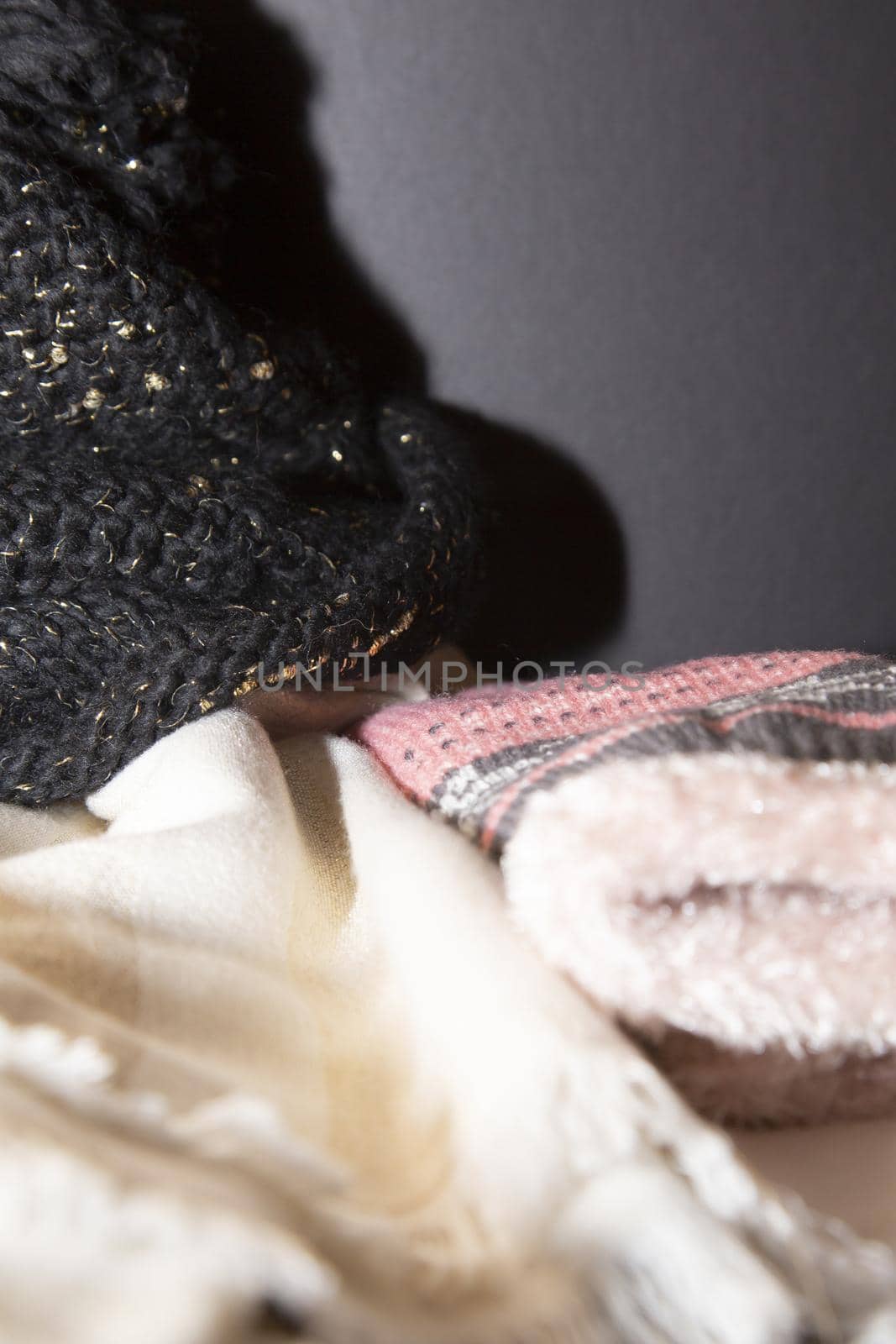 White and gold scarf, black and gold winter hat, and pink and grey winter gloves