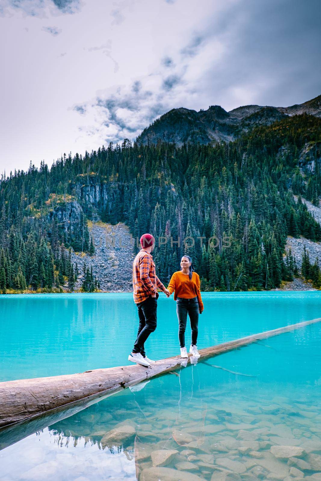 Majestic mountain lake in Canada. Upper Joffre Lake Trail View, couple visit Joffre Lakes Provincial Park - Middle Lake. British Columbia Canada, couple men and woman hiking by the lake