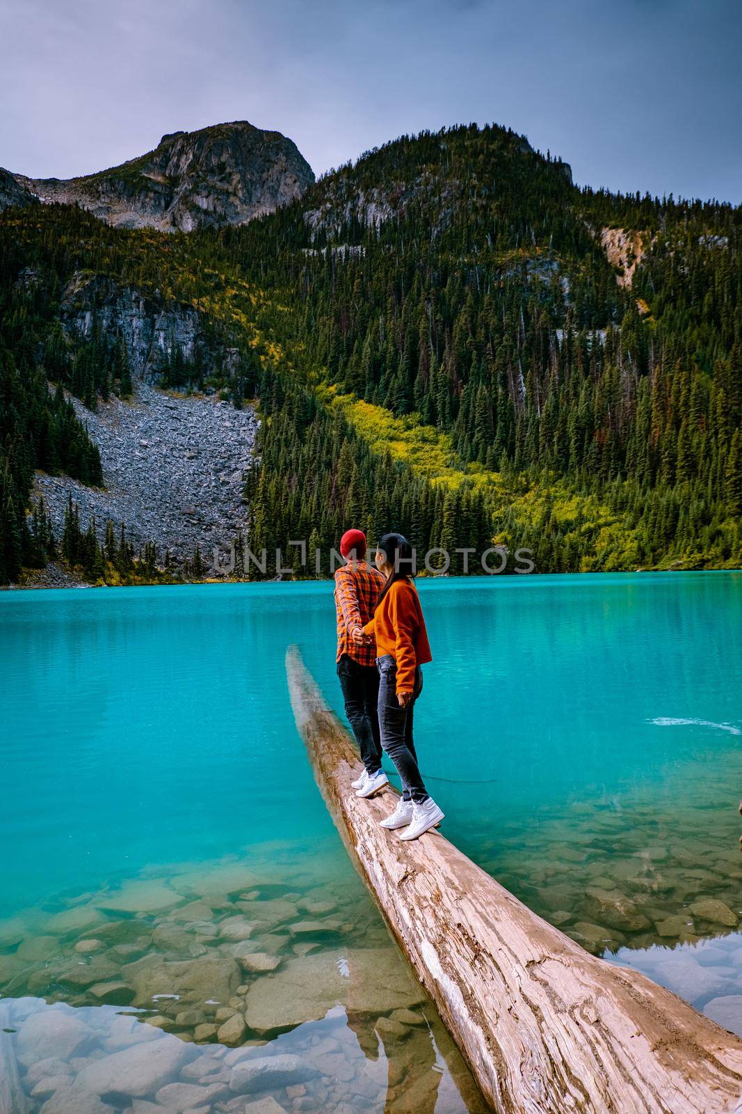 Majestic mountain lake in Canada. Upper Joffre Lake Trail View, couple visit Joffre Lakes Provincial Park - Middle Lake. British Columbia Canada, couple men and woman hiking by the lake