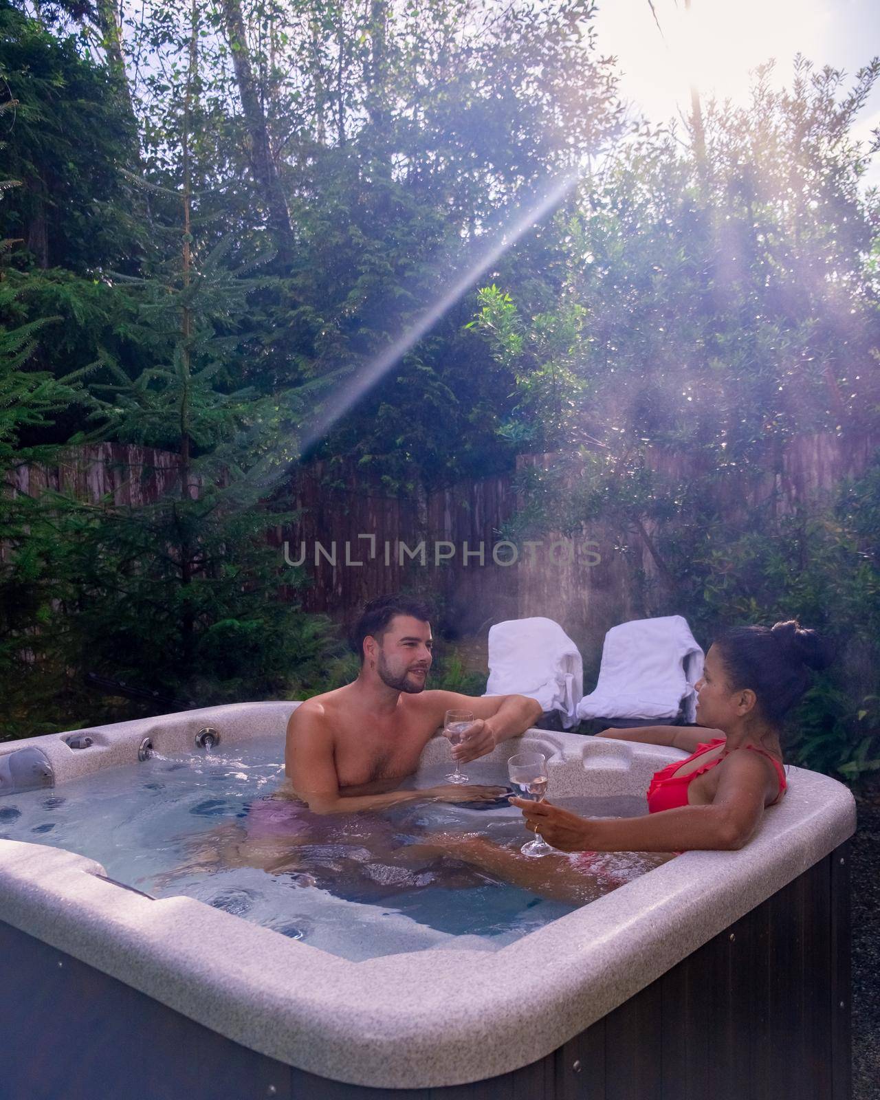 Couple mid age enjoying in a romantic atmosphere of a luxury spa wellness resort, having a bath in a jacuzzi tub Vancouver Island Canada