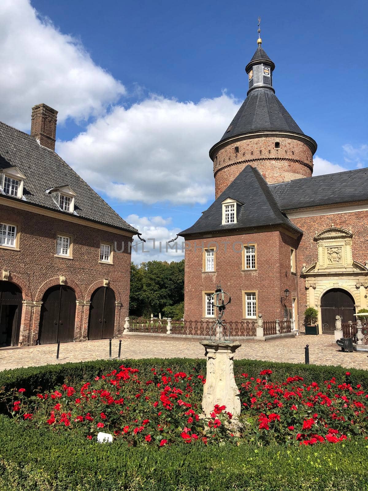 Statue and flowers at the Wasserburg Anholt castle in Munsterland, Germany