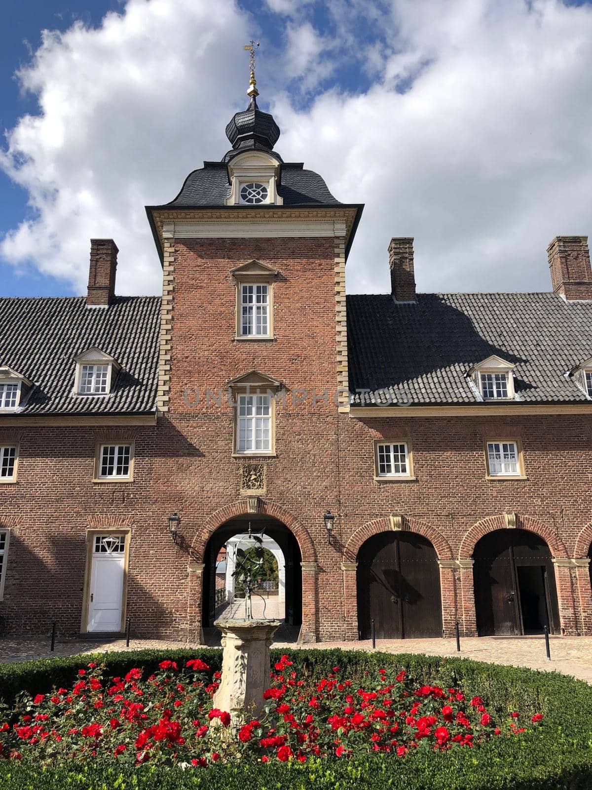 Statue and flowers at the Wasserburg Anholt castle by traveltelly