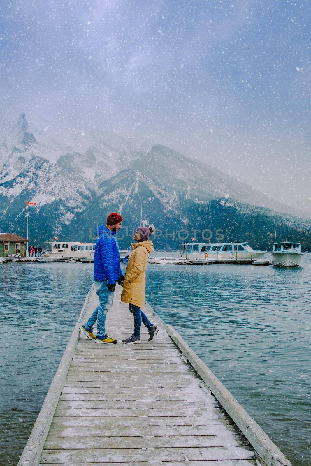 Minnewanka lake in Canadian Rockies in Banff Alberta Canada with turquoise water is surrounded by coniferous forests. Lake Two Jack in the Rocky Mountains of Canada. couple hiking by the lake Banff Canada