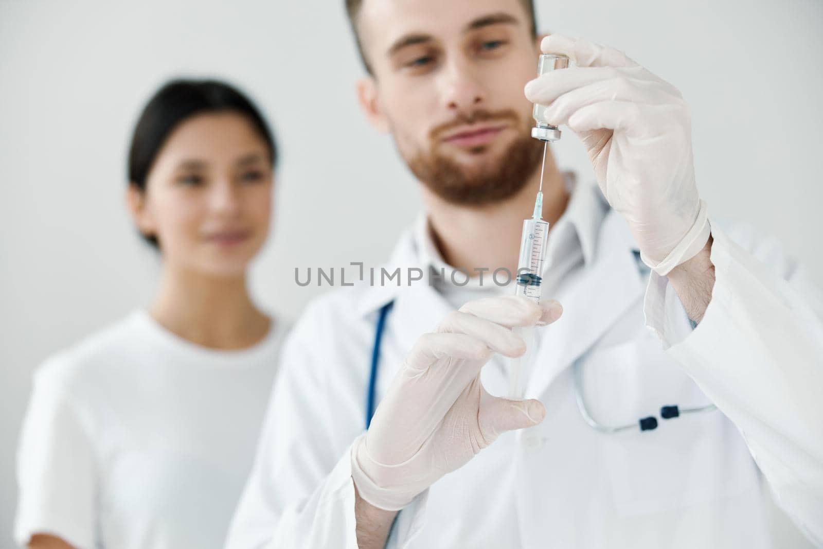 woman looking at doctor with syringe in hand vaccination medical gloves stethoscope by SHOTPRIME