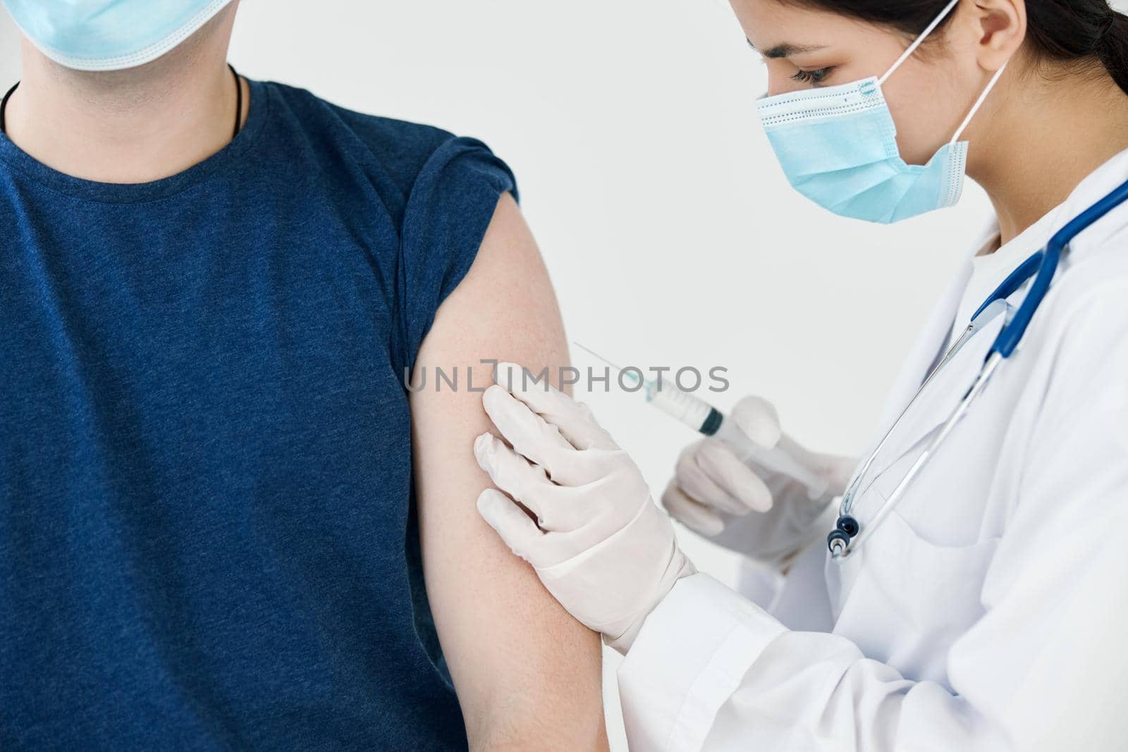 beautiful woman doctor in medical mask giving an injection to a patient vaccination by SHOTPRIME