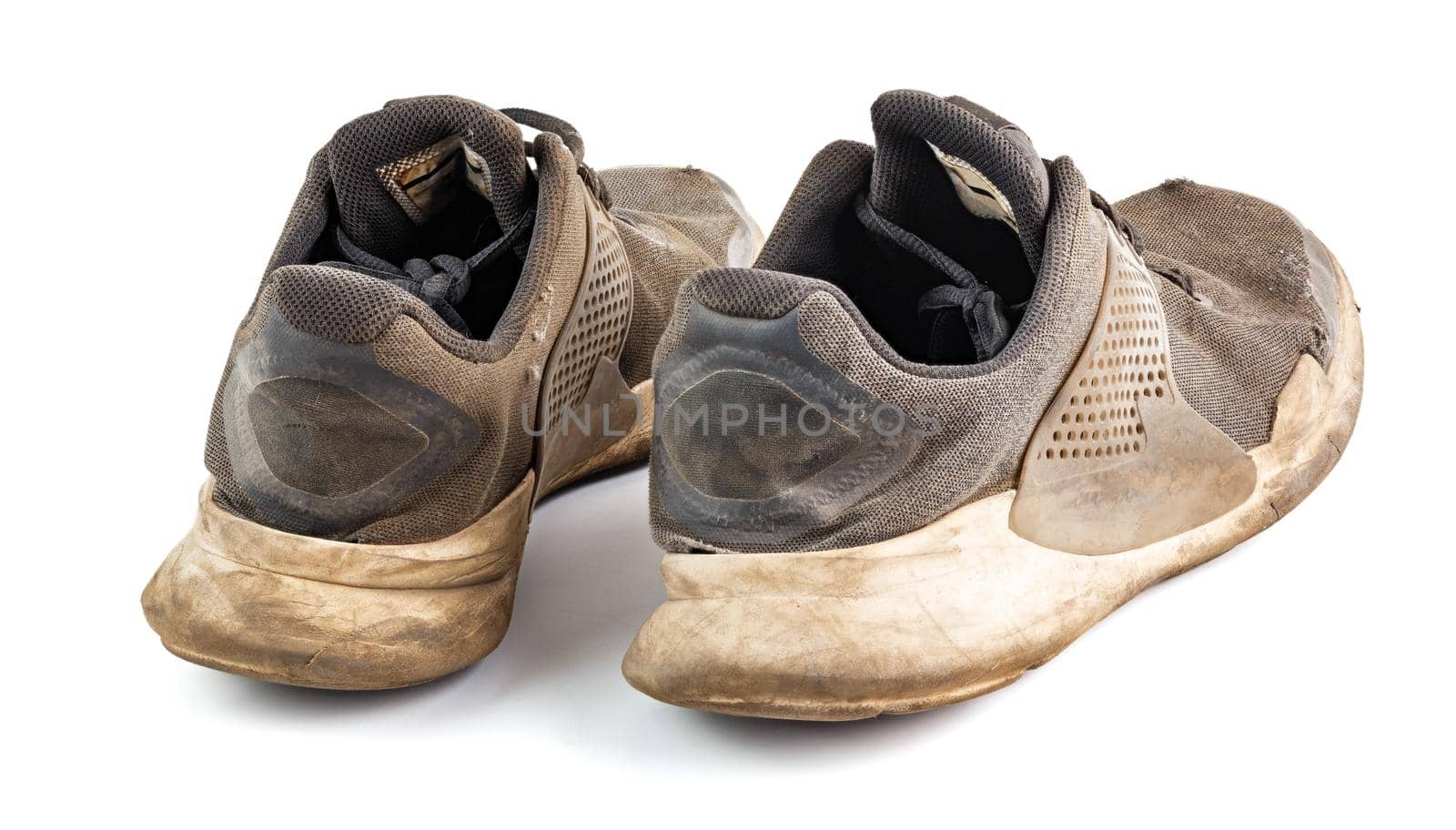 a pair of weared dirty sneakers isolated on white background, edge-to-edge sharpness, rear view
