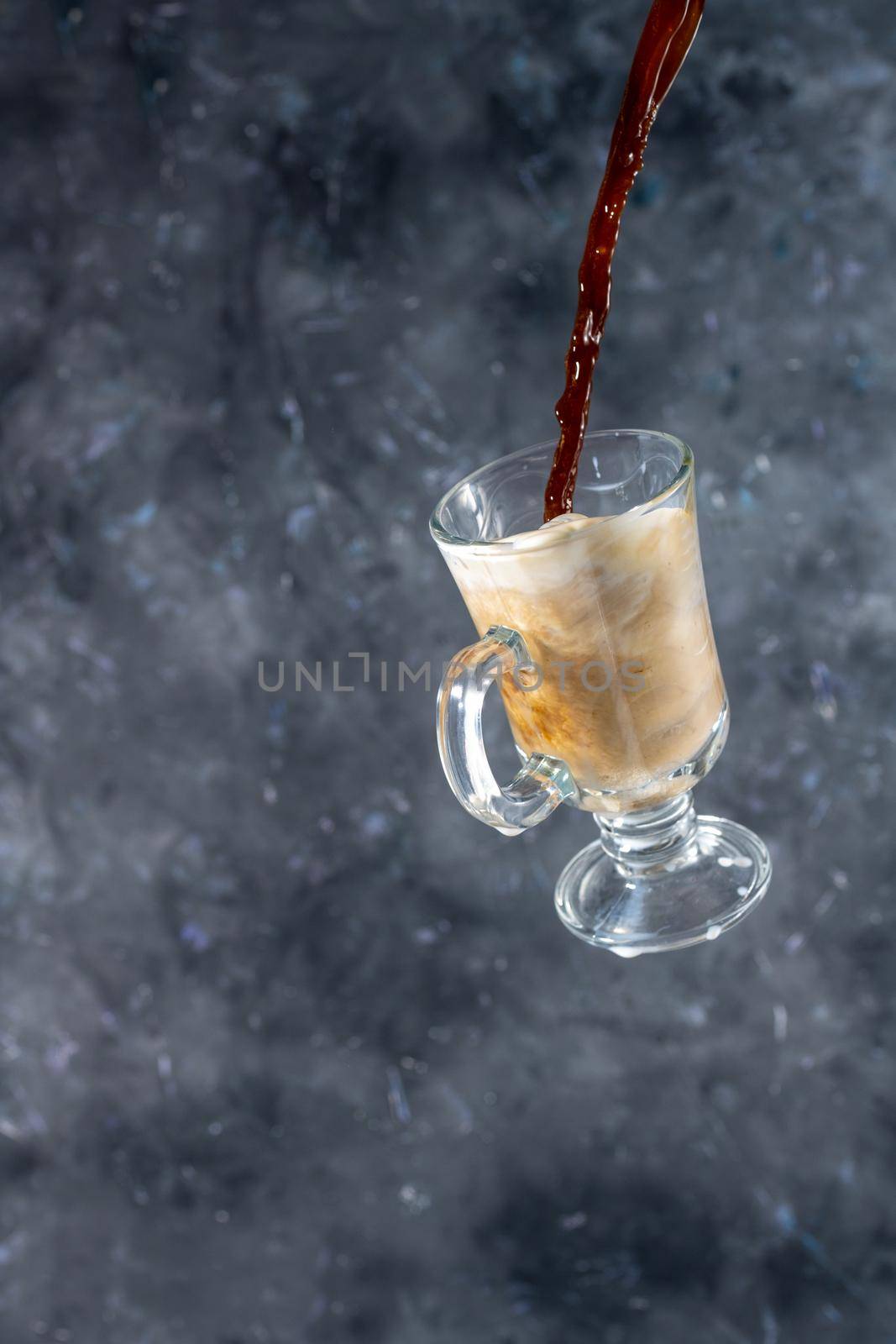 coffee with milk and cookies in the shape of hearts. the process of pouring coffee into a glass of milk. levitation