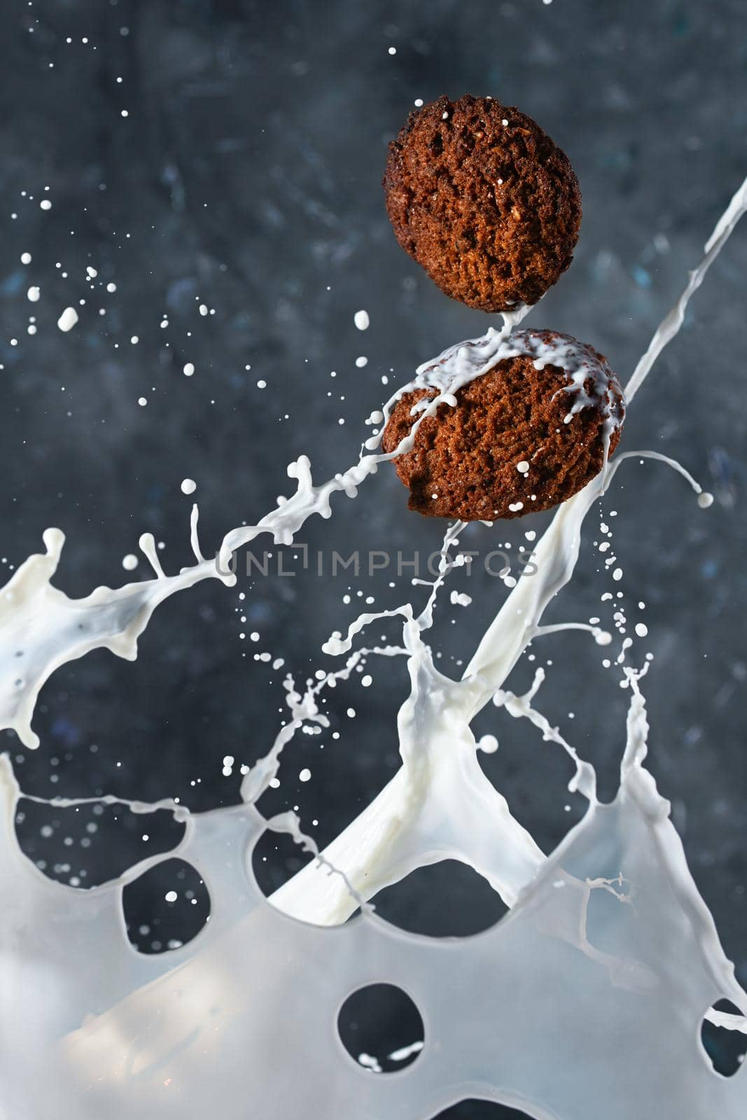 Oatmeal cookies with milk splashes on gray background. levitation