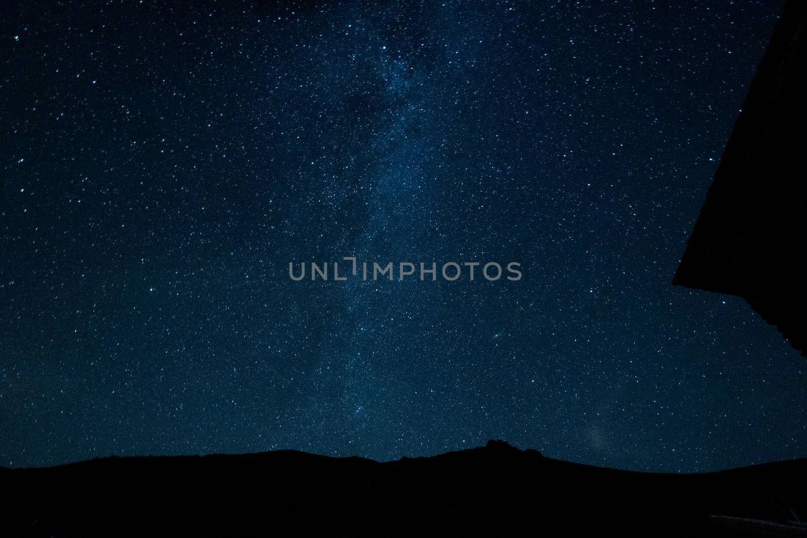 Starry sky surrounded by mountains and the via láctea