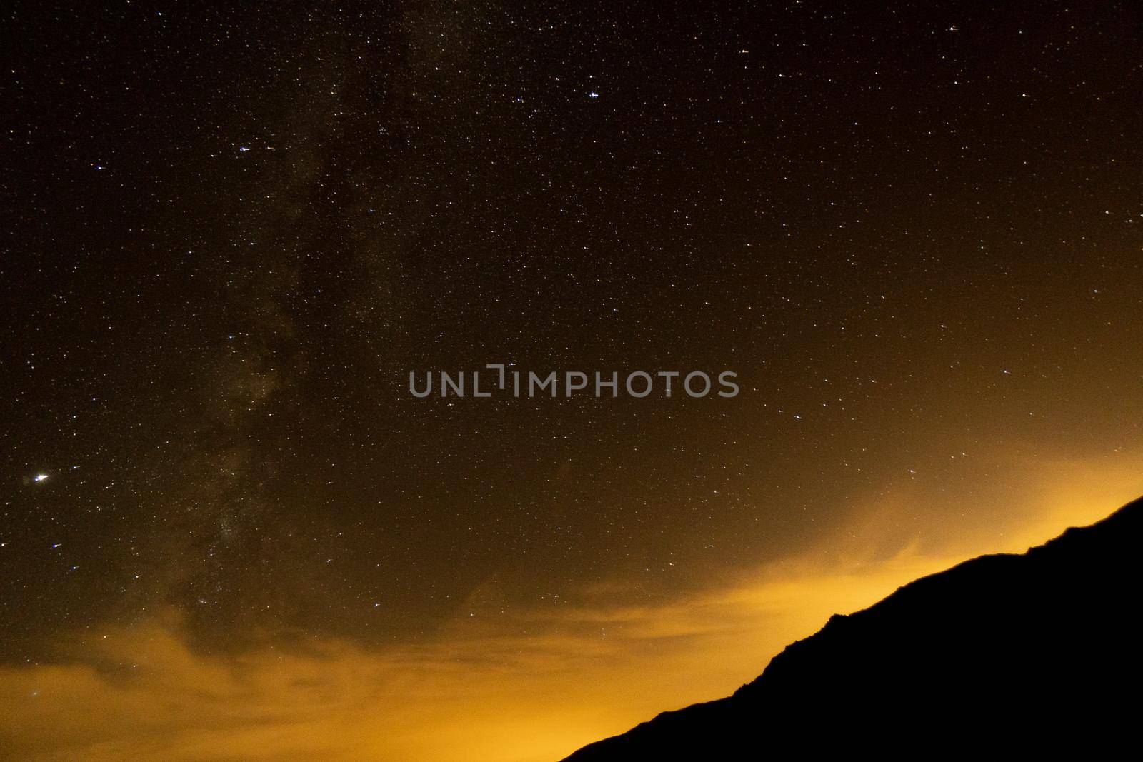 Starry sky surrounded by mountains and the via láctea
