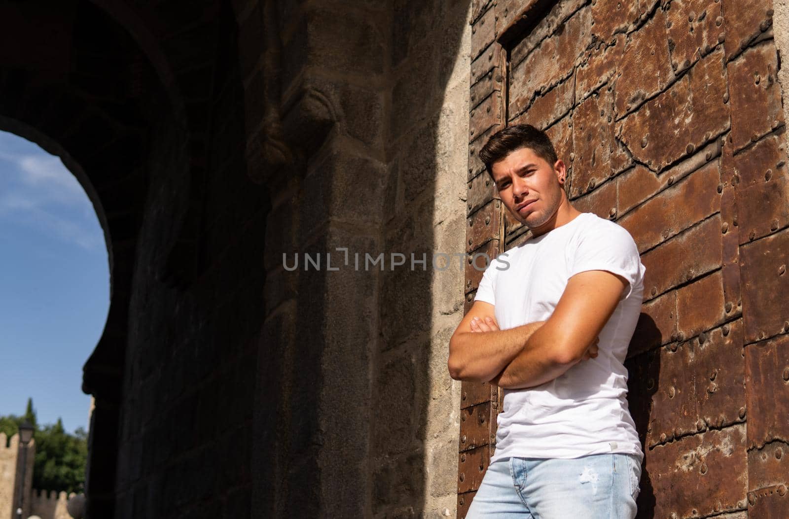 Man with an intense look on a rusty background, white T-shirt and black earring