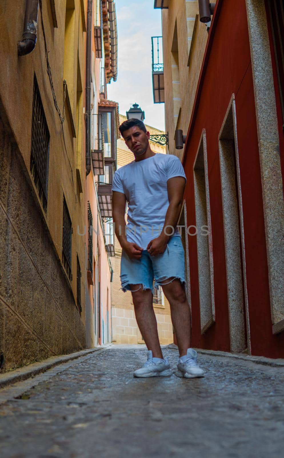 Strong guy with white T-shirt in a colorful alley