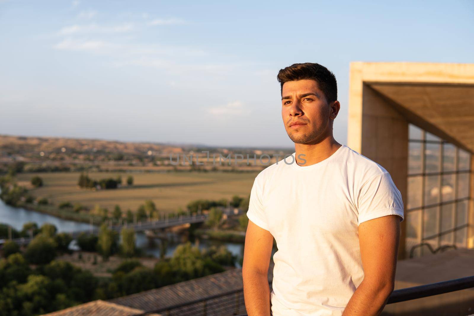 Boy with white T-shirt and brown hair with sky in the background