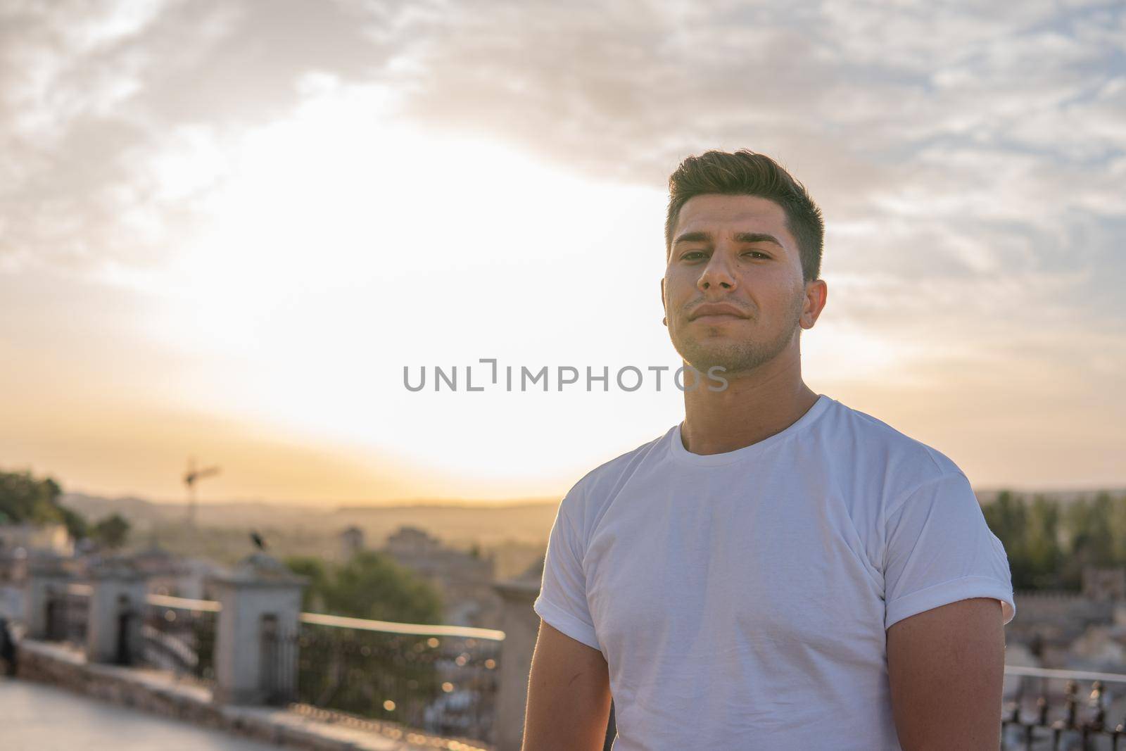 Boy with white T-shirt and brown hair with sky in the background