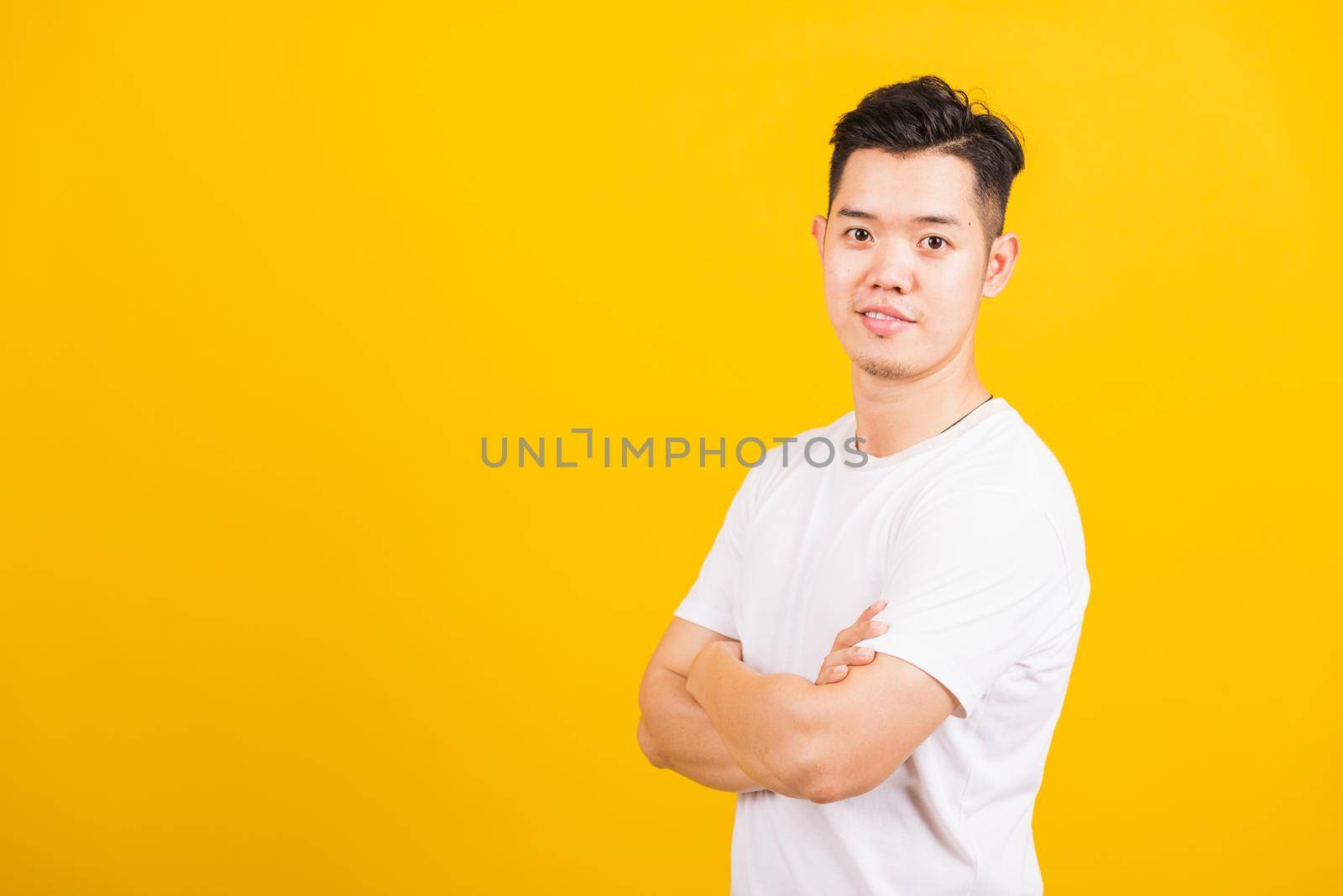 handsome young man smiling standing folded or crossed arm by Sorapop