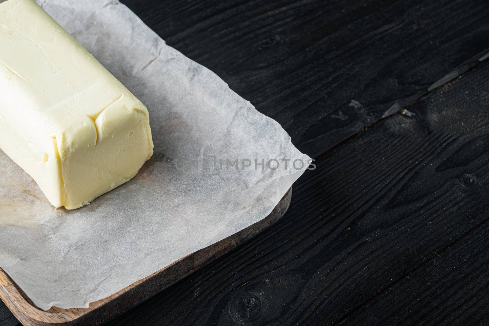 Fresh butter package, on black wooden table background with copy space for text