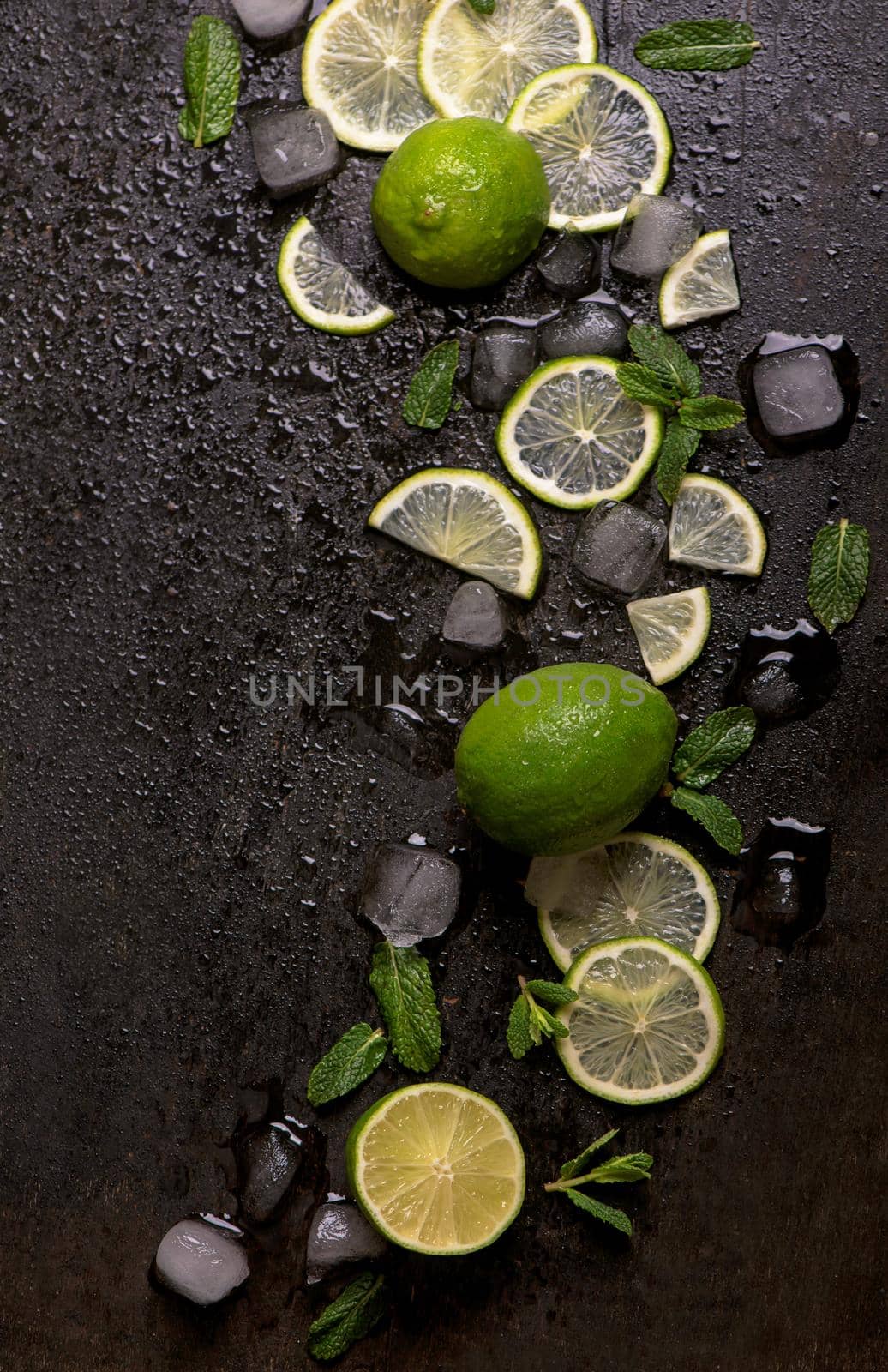 Fresh mint, lime and ice on a black background. Ingredient for mahito. by aprilphoto