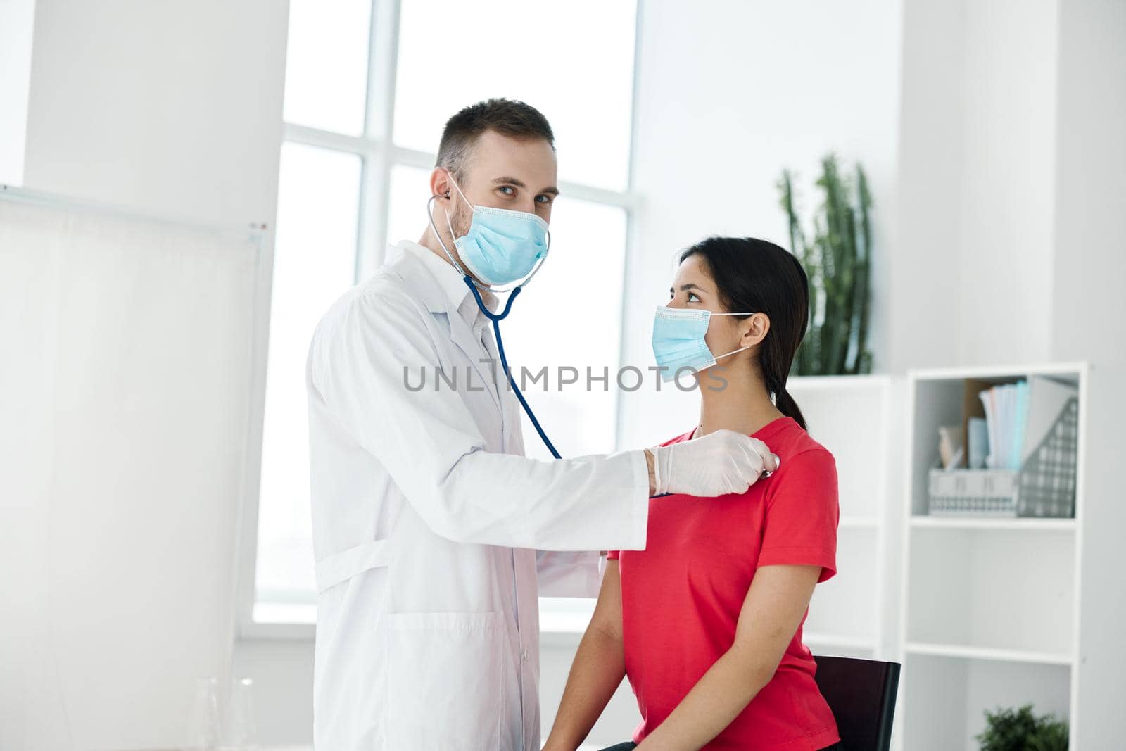 doctor examines woman in medical mask red t-shirt stethoscope by SHOTPRIME