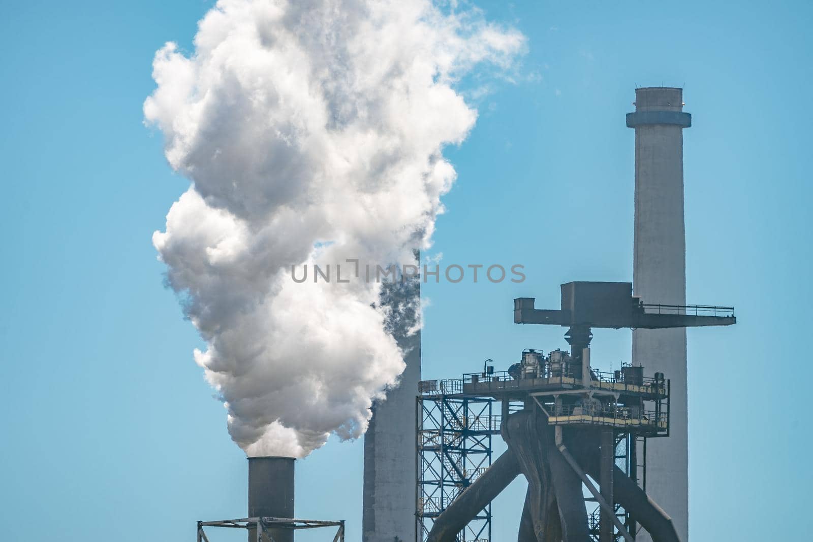Smoke or steam emissions from steel mill factory - Industrial pollution concept by Pendleton