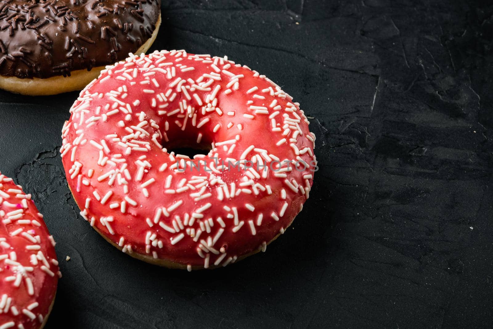 Pink strawberry flavor donuts, on black background with copy space for text