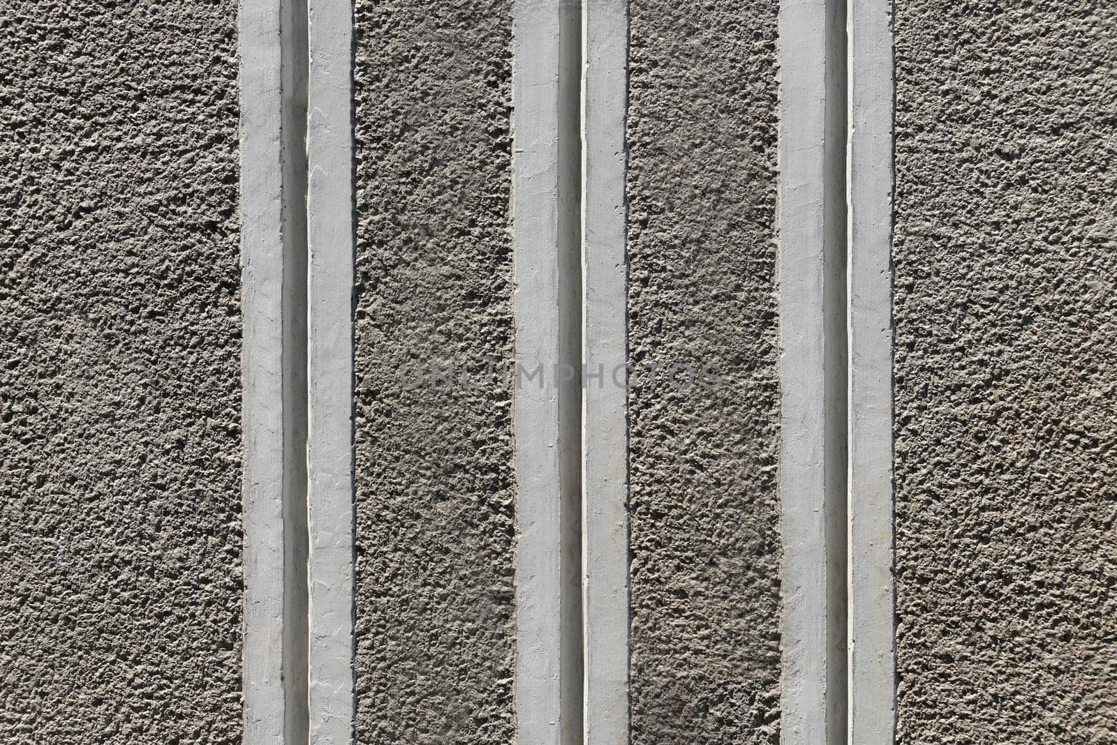 Gray rough concrete wall with striped vertical stripes close-up.Texture or background