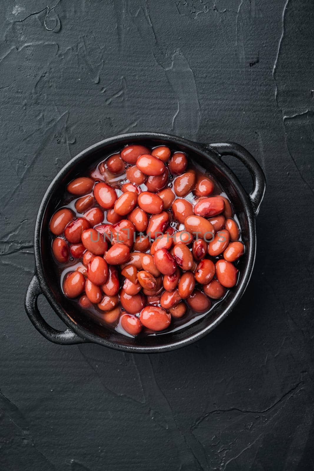 Red beans canned food, on black background, top view flat lay