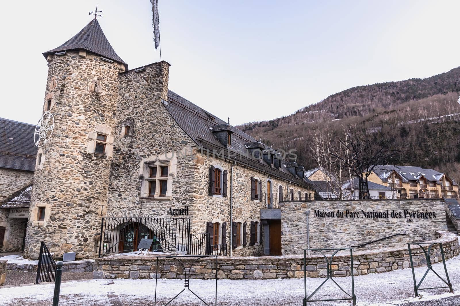 Saint Lary Soulan, France - December 26, 2020: architectural detail of the Maison Du Parc National Des Pyrenees (house of the Pyrenees National Park) in the historic city center where tourists walk on a winter evening