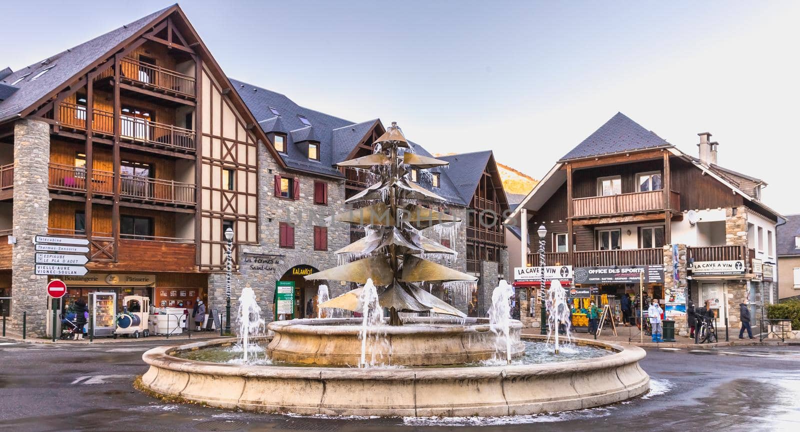 Saint Lary Soulan, France - December 26, 2020: fountain in the city center frozen by the cold on a winter day