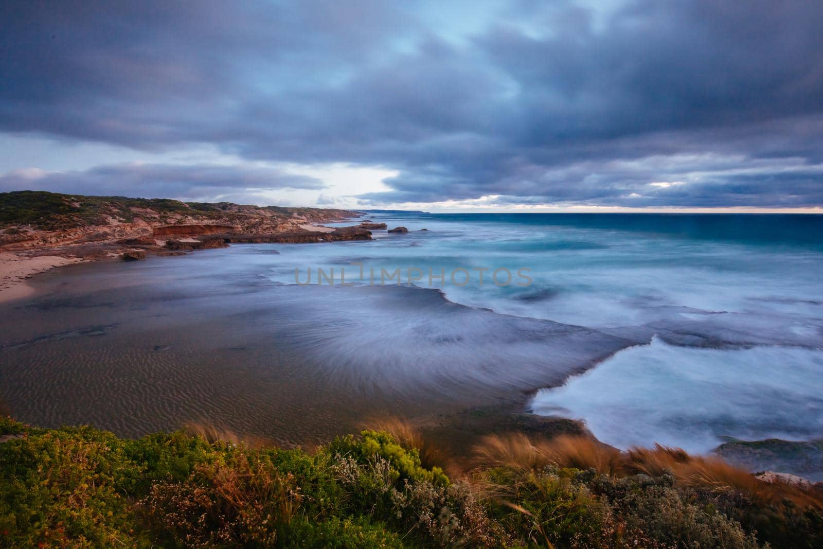 The idyllic Pearses Beach and headland around Pirates Bay Cove on a hot summer's evening near Blairgowrie, Victoria, Australia