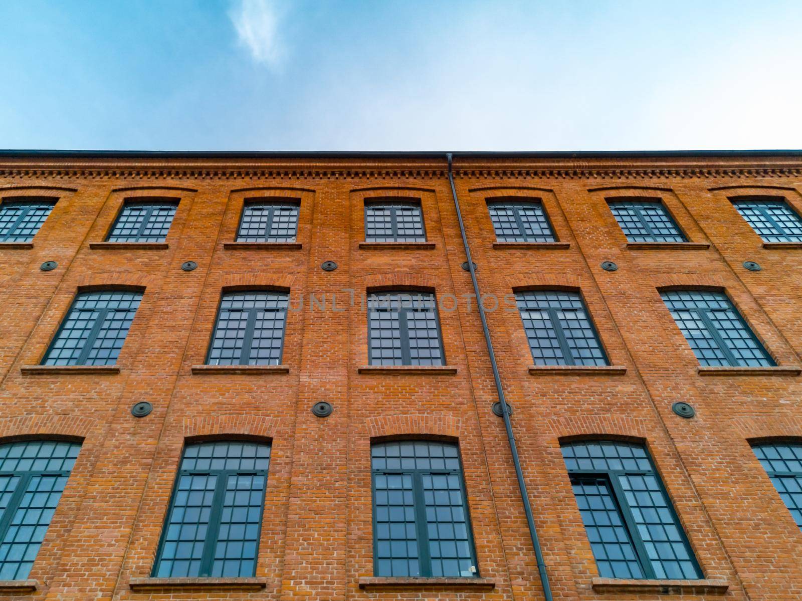 Upward view to high red brick building with a lot of windows