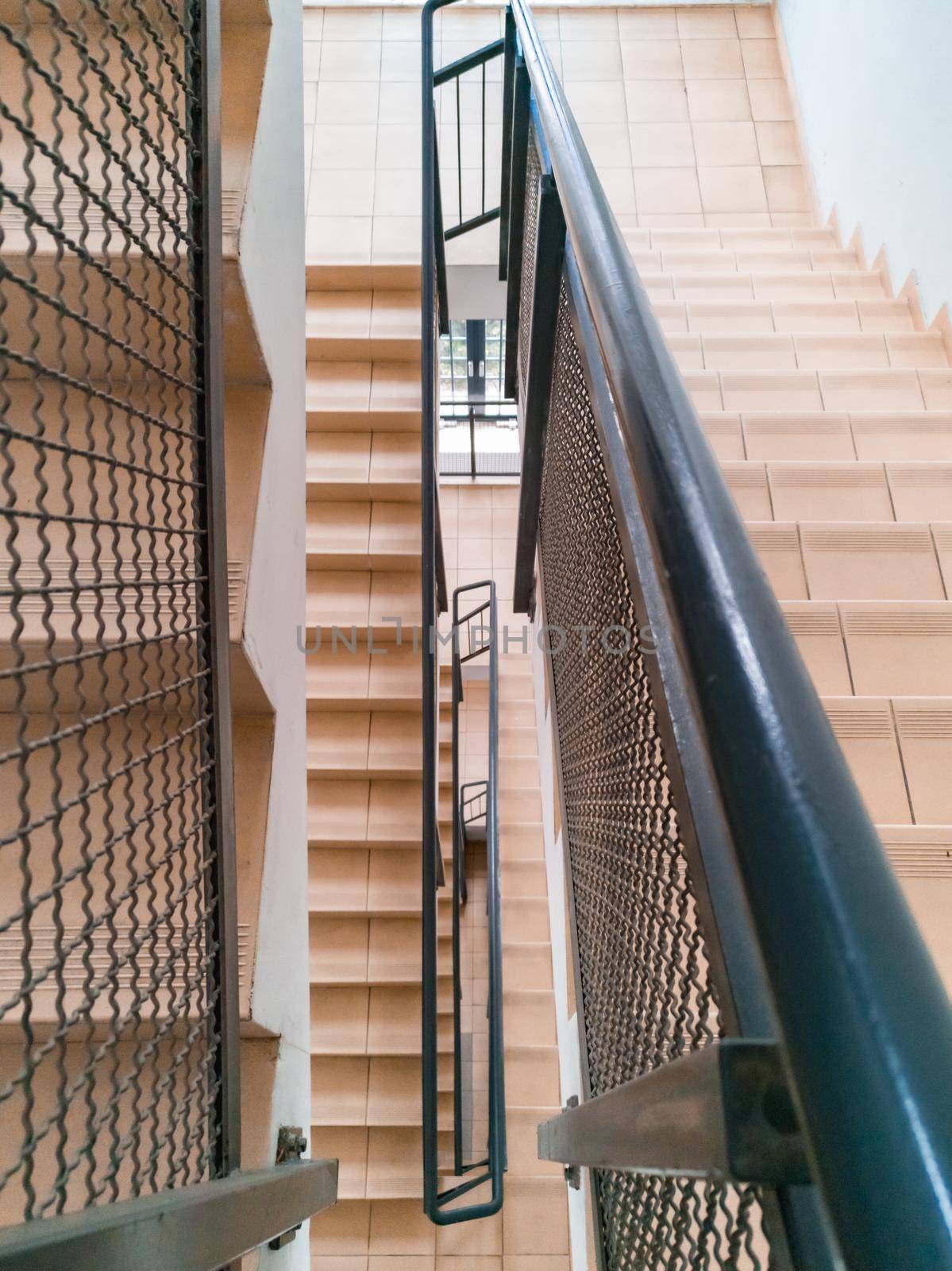 Top down view to modern staircase with light stairs and metal railings by Wierzchu