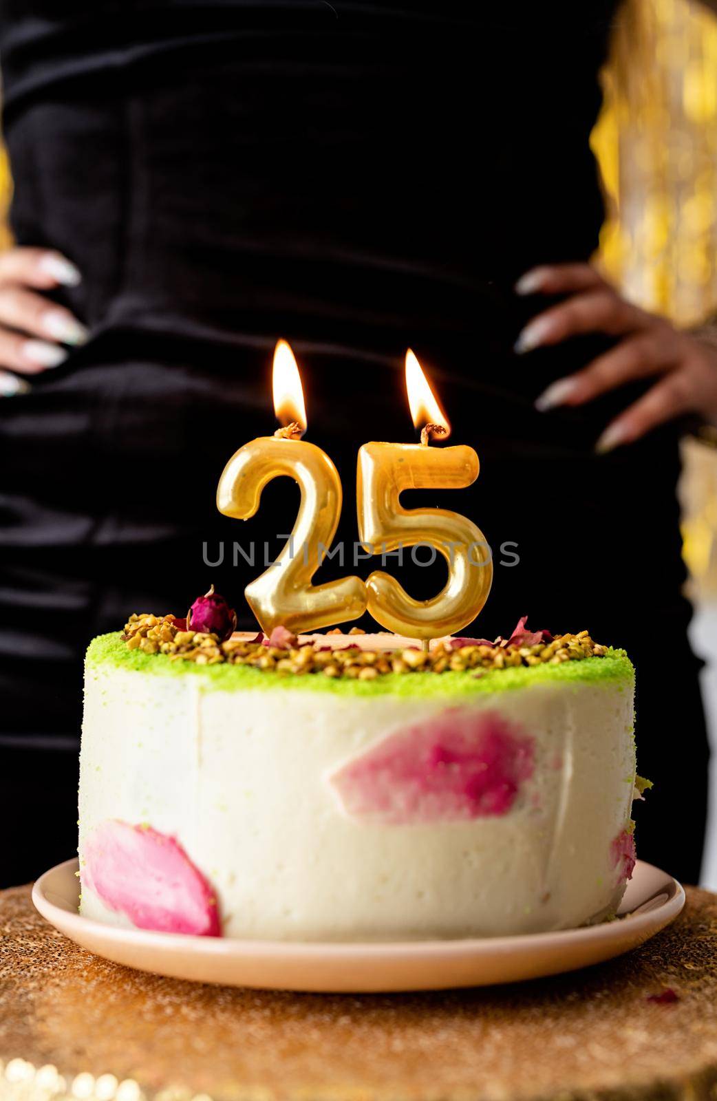 Birthday party. Woman in black party dress ready to eat birthday cake celebrating her twenty fifth birthday